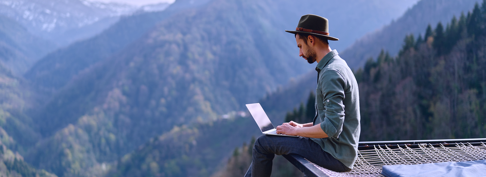 man with laptop on top of mountain